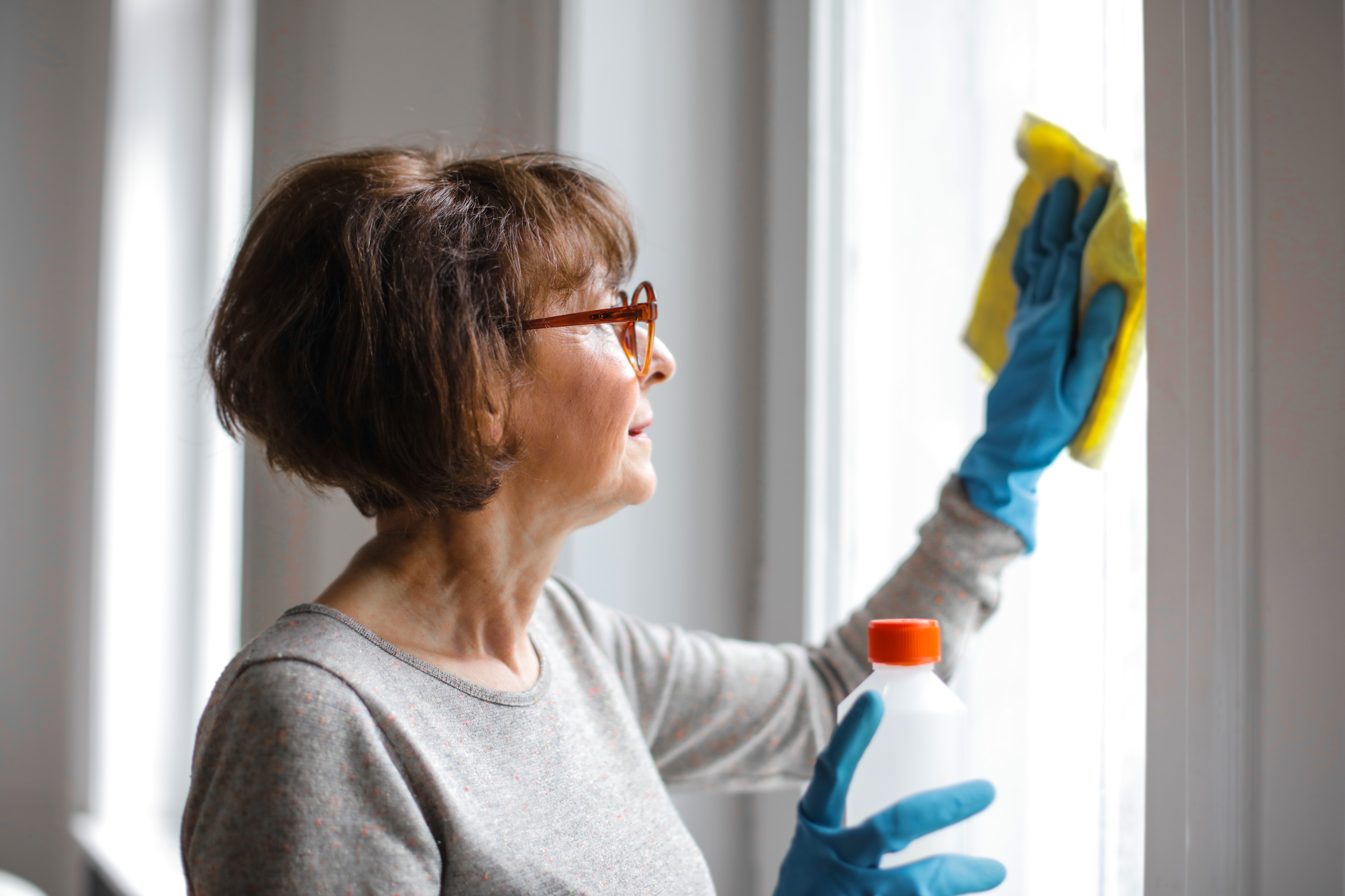 a women cleaning the house and keeping the elbows in to avoid shoulder injuries at home