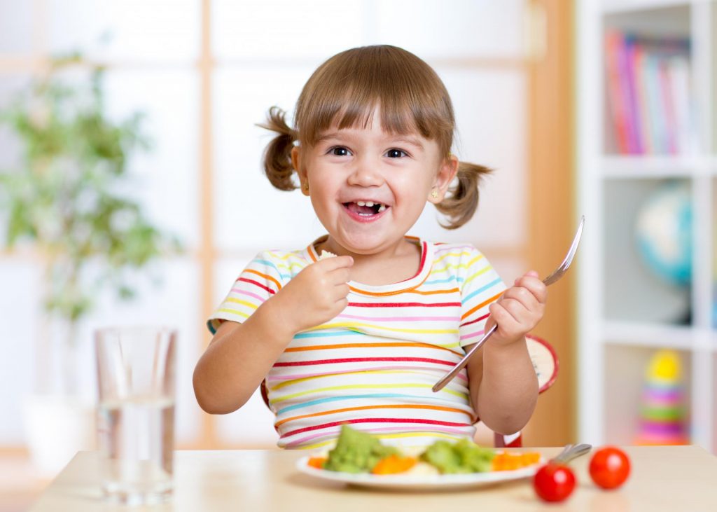 child eating vegetable
