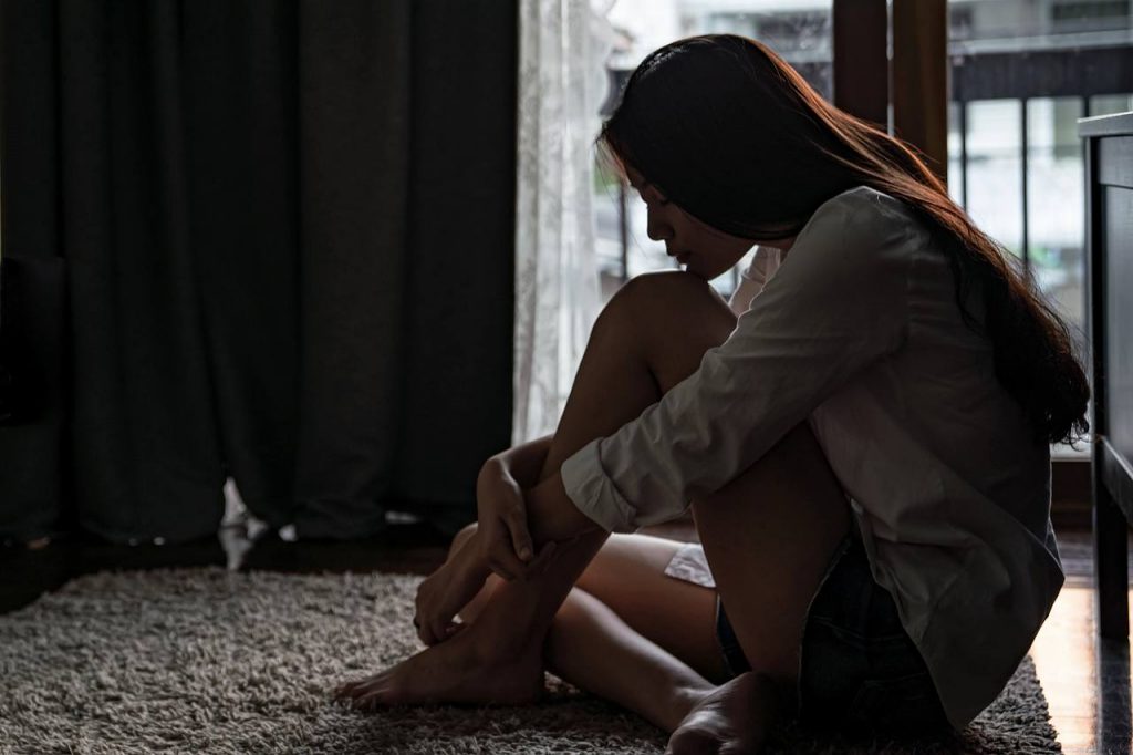 girl being depressed sitting in the dark