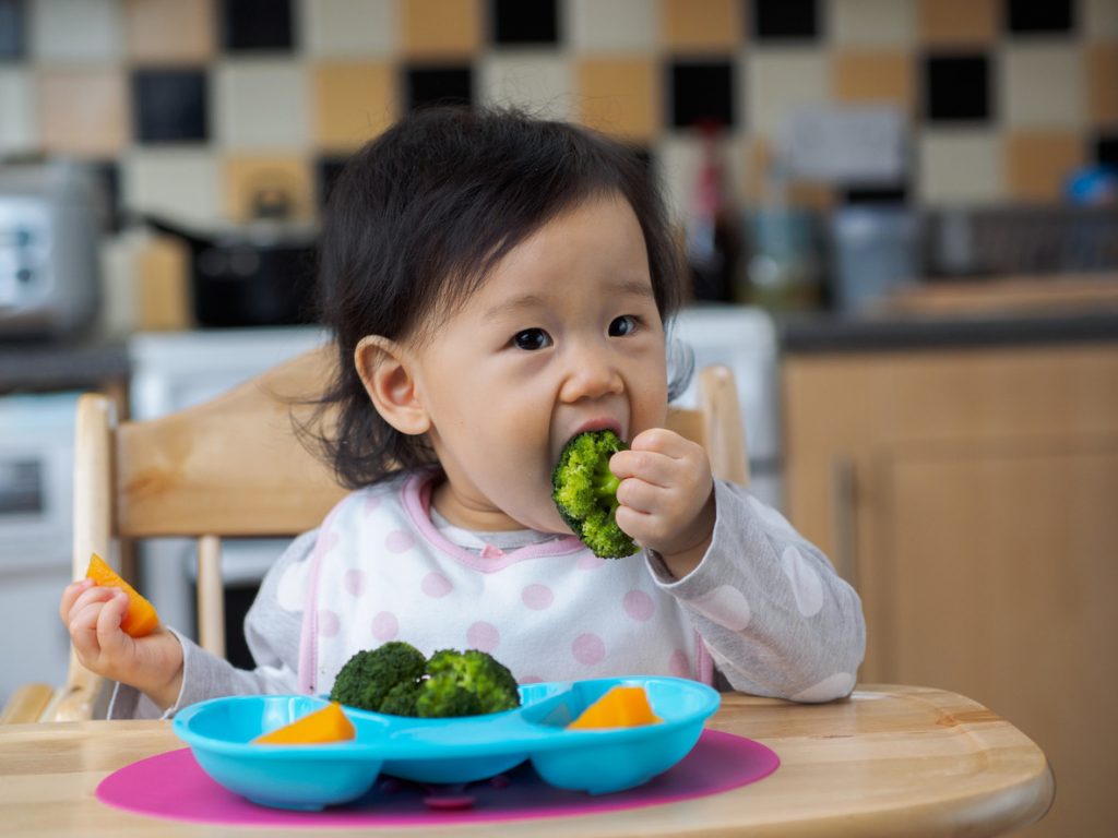 an image of a child eating solid foods baby-led weaning 