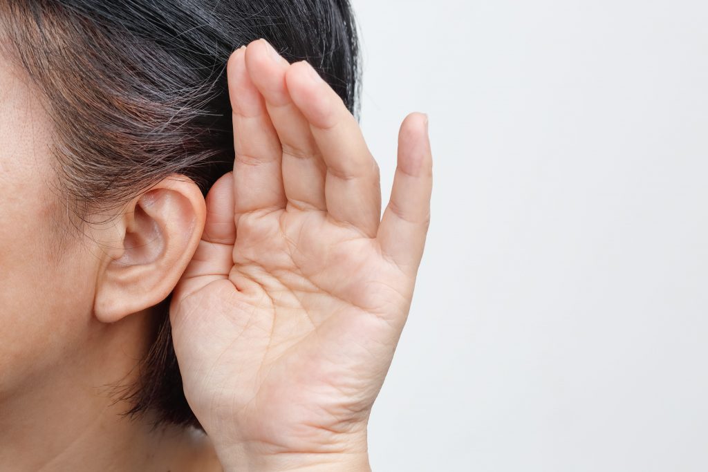 a person putting their hand near the ear because they cannot listen properly hearing loss