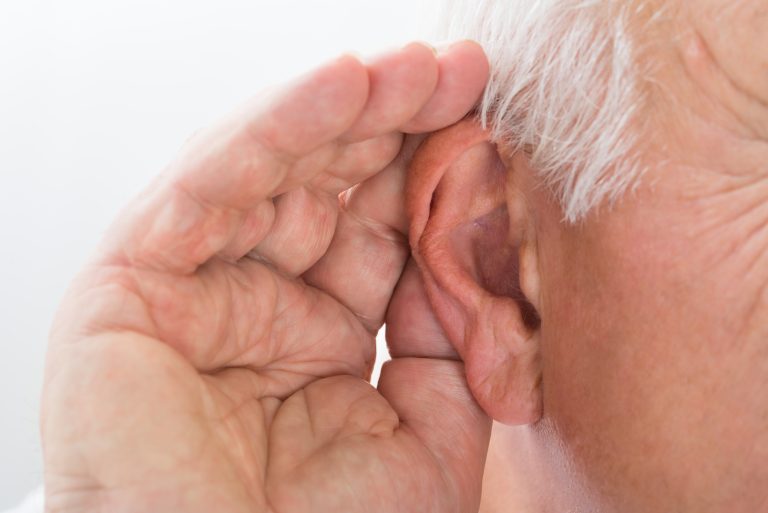 an image showing an elderly having hearing problem or hearing loss