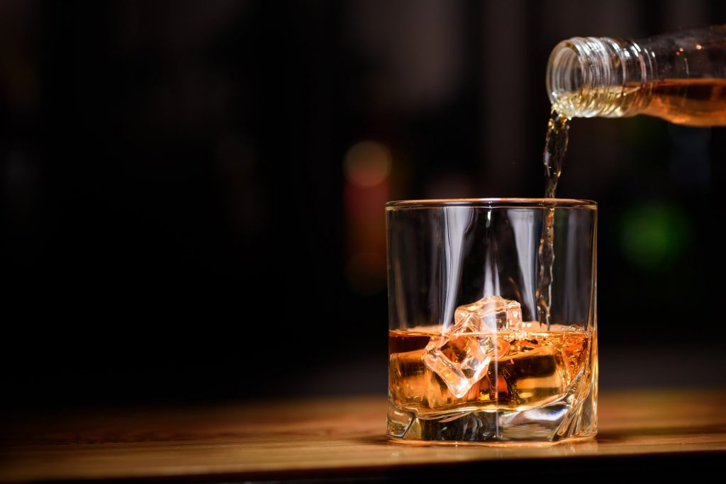 consuming alcohol safely a picture of whiskey being poured into a glass
