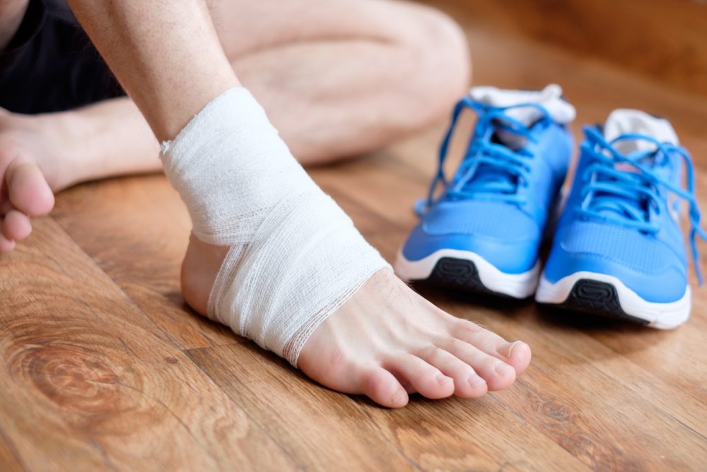 man with his injured sprained ankle 